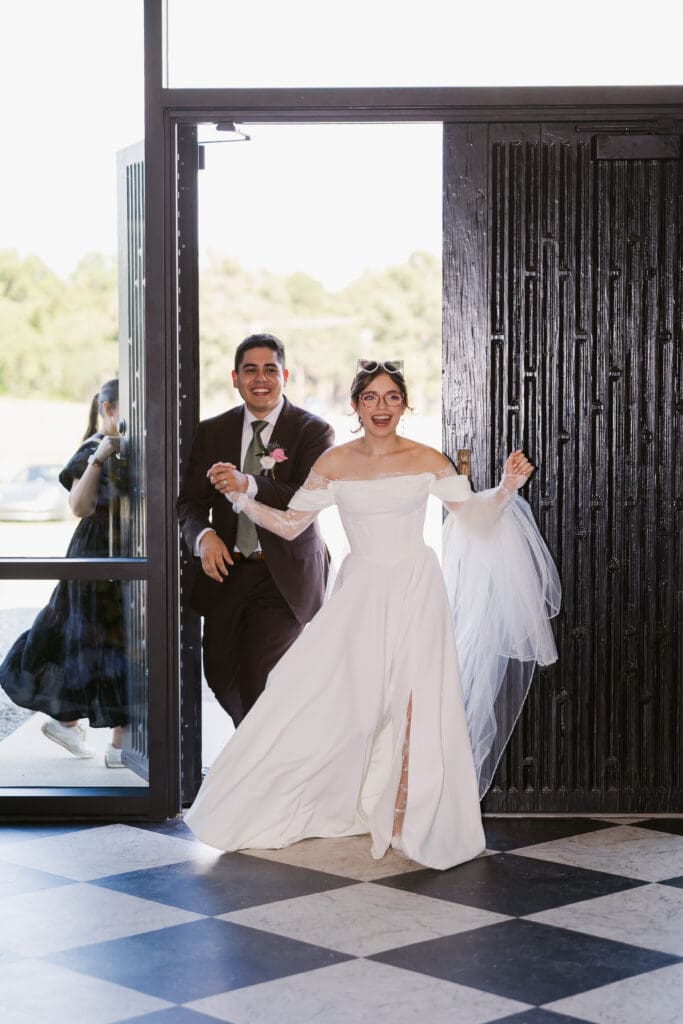 The bride and groom make a joyful wedding grand entrance.