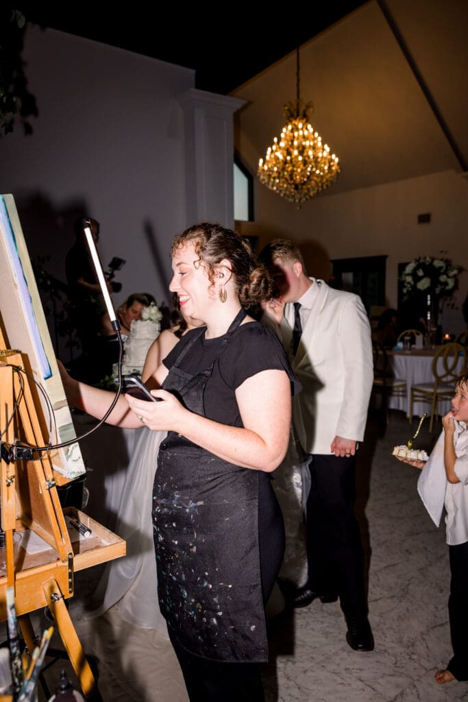 Live wedding painter enjoys an upbeat wedding reception.